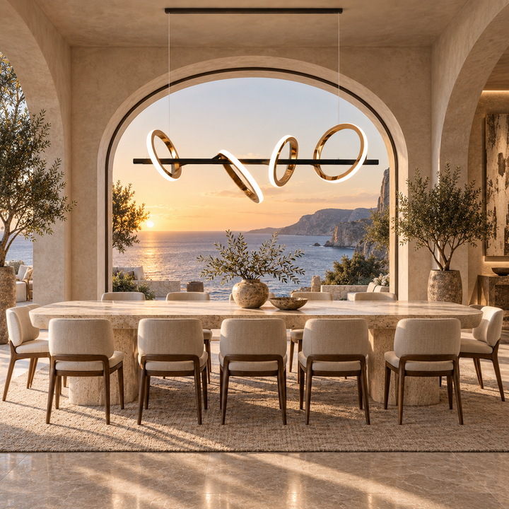 Soleil Custom 5A linear pendant light with rose gold rings above a travertine dining table framed by an arched sunset sea view