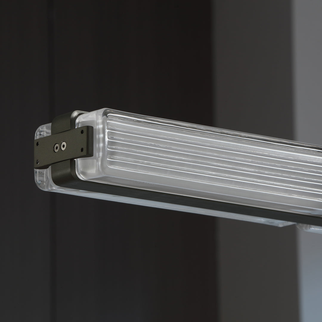 detail view of Striato 10 linear pendant with gunmetal finished frame and ribbed glass creating refined modern designer lighting