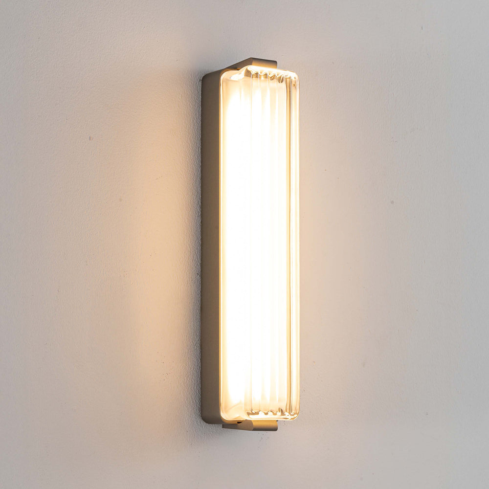 Striato LED wall light featuring ribbed glass panel and warm ambient lighting ideal for bedroom wall light and modern home lighting.