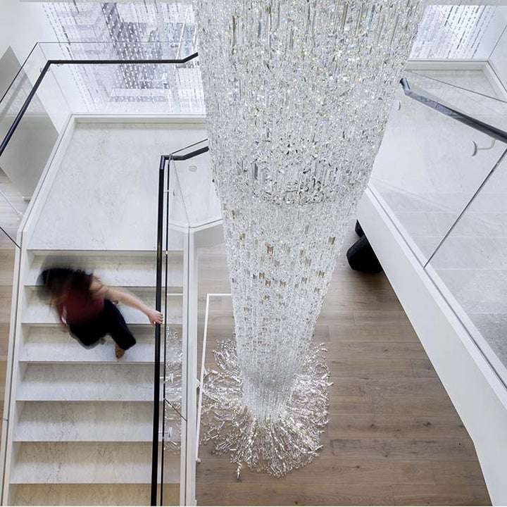 Lucretia Lighting Waterfall bespoke lighting void crystal chandelier installed above staircase in a luxury interior setting