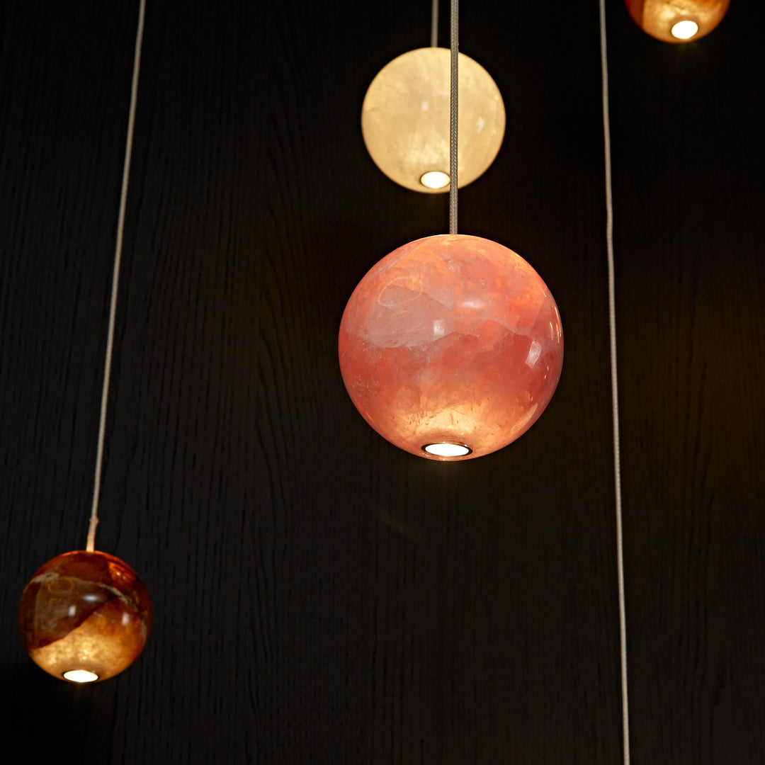 Mixed natural agate pendant lights combining white, rose and honey agates in a bespoke architectural lighting composition.