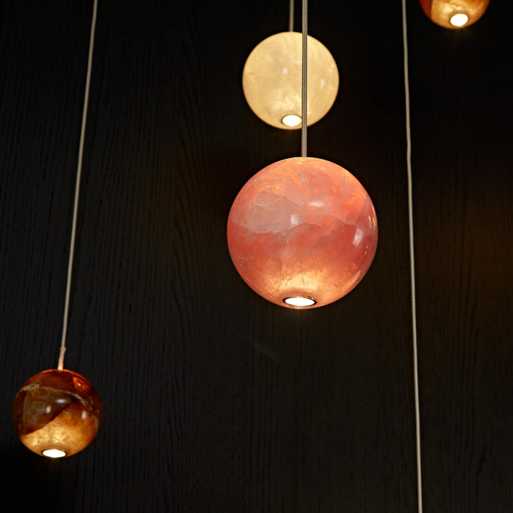 Mixed natural agate pendant lights combining white, rose and honey agates in a bespoke architectural lighting composition.