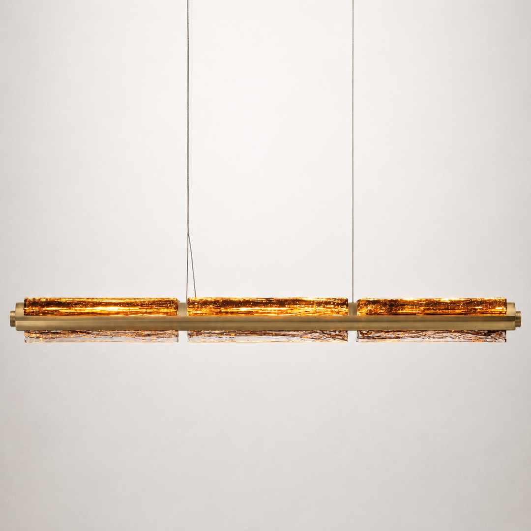 Running Water Horizon linear pendant light with smoked amber hand-blown textured glass in antique brass.