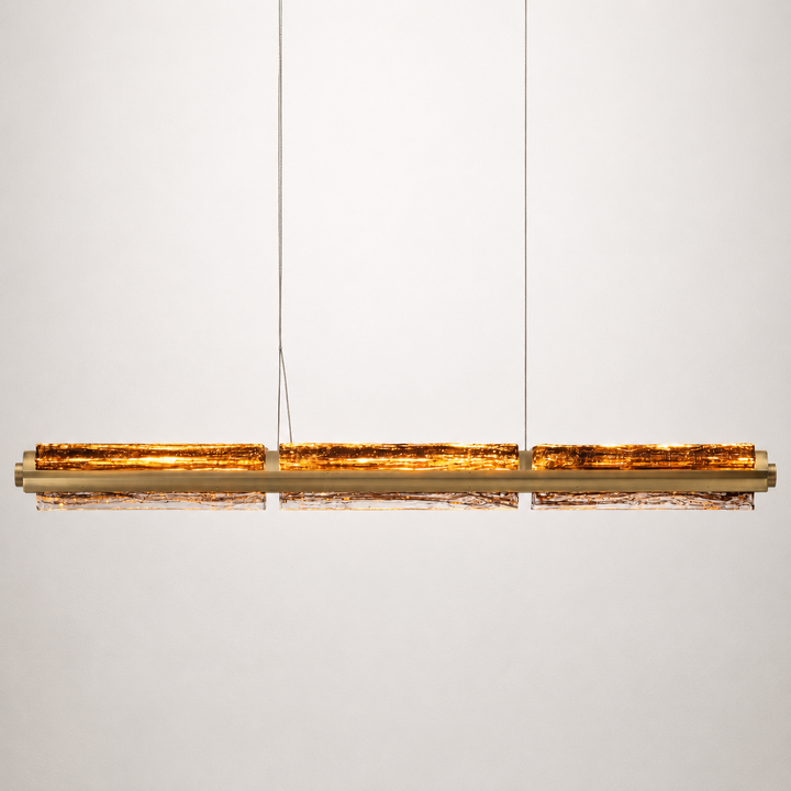 Running Water Horizon linear pendant light with smoked amber hand-blown textured glass in antique brass.
