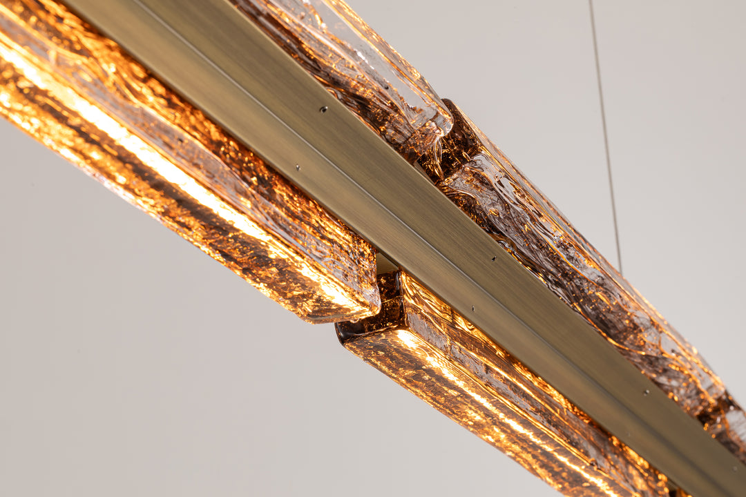 Close-up of smoked clear textured glass with integrated LED linear pendant lighting.