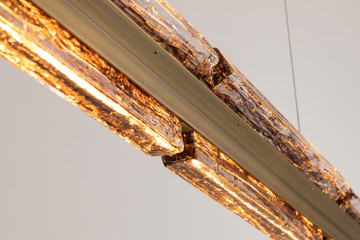 Close-up of smoked clear textured glass with integrated LED linear pendant lighting.
