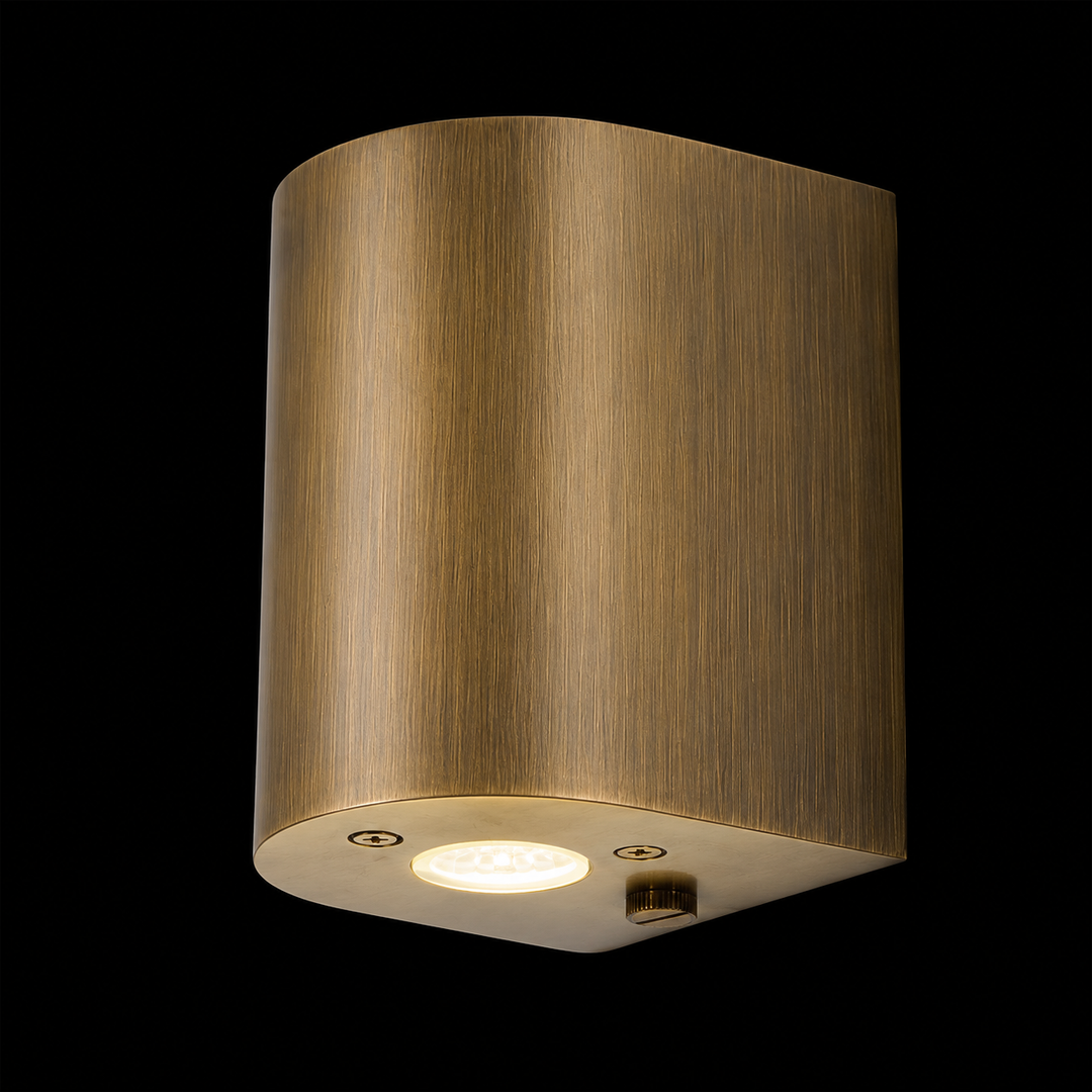 Solid brass cylinder outdoor wall light in antique brass finish featuring a handcrafted cylindrical design with integrated LED for contemporary outdoor architecture.