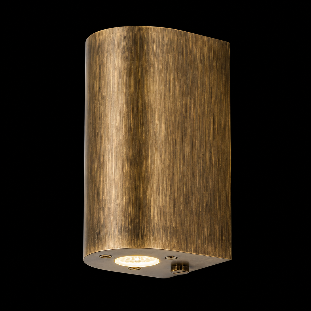 Handcrafted solid brass cylinder outdoor wall light in antique brass finish with integrated LED for luxury exterior architecture.