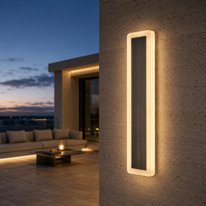 Solid brass modern outdoor wall light with illuminated acrylic frame mounted on a contemporary exterior wall, creating warm architectural lighting for luxury homes.