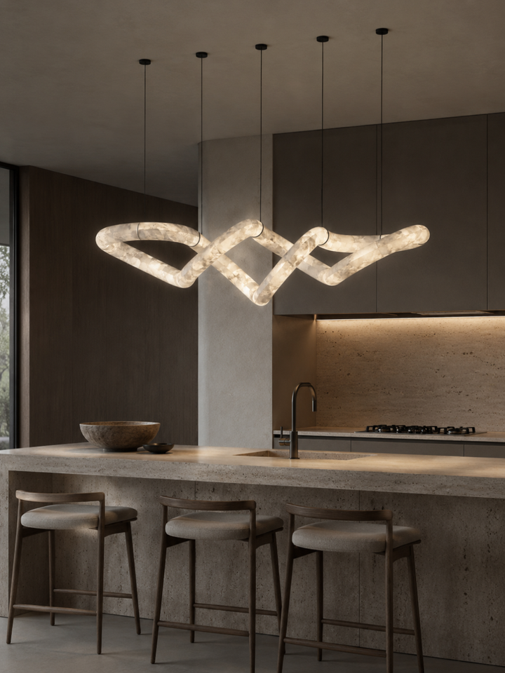 Luxury Spanish alabaster linear pendant light illuminating a modern kitchen island with bespoke architectural lighting.