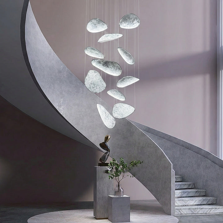 Moonlit modern chandelier installed in stair void with cascading illuminated acrylic panels