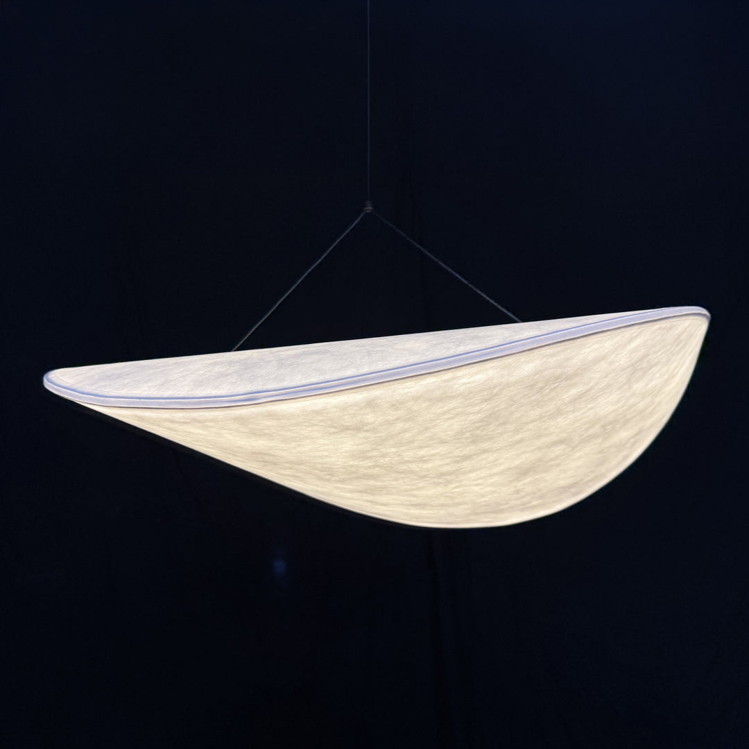 a close-up view of an organic cocoon-style pendant light with soft diffused illumination and a smooth, atmospheric glow