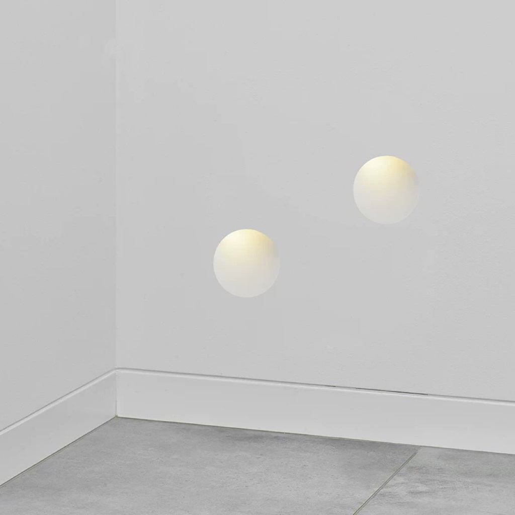 oval gypsum wall lights installed in a hallway corner providing diffused warm ambient wall lighting