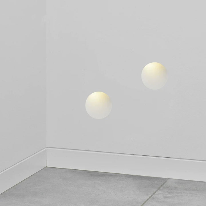 oval gypsum wall lights installed in a hallway corner providing diffused warm ambient wall lighting