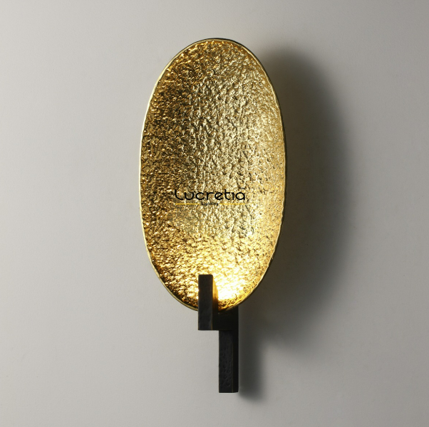 sculptural brass oval wall light shown in angled view suitable for modern indoor wall lighting ambient hallway wall light and refined contemporary home interiors