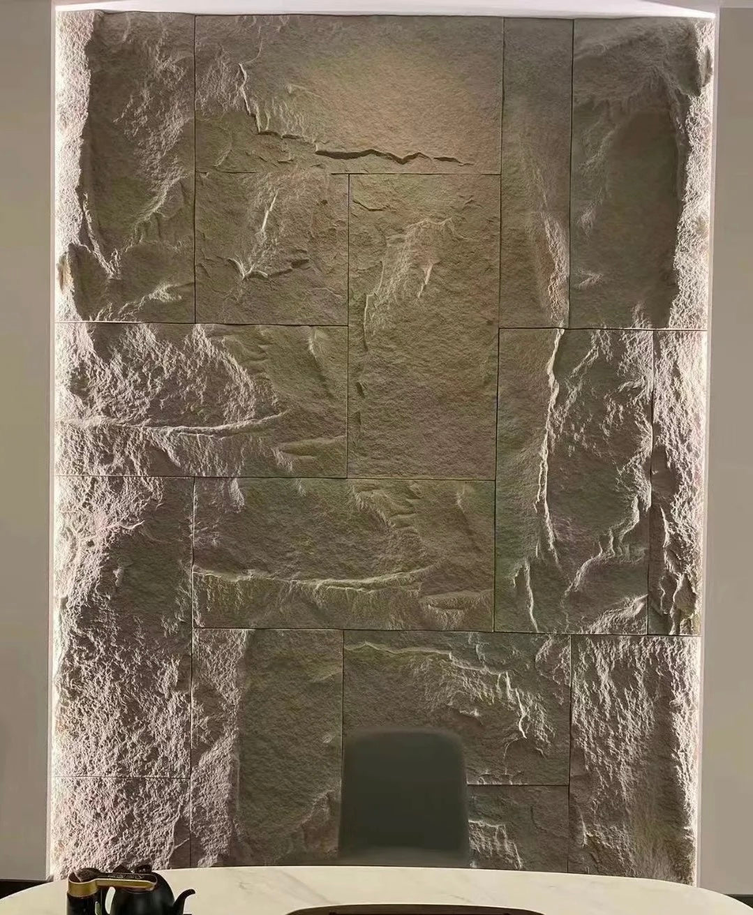 Lightweight PU rock wall panel showing realistic dark stone texture and panel thickness