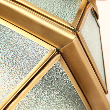 Close-up of brass lantern corner showing frosted glass and metal frame detail.