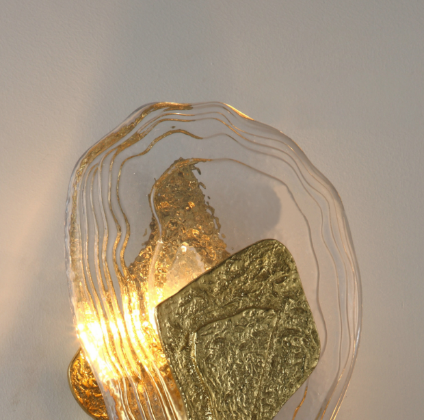 sculptural crystal and brass reliquia wall light creating decorative ambient lighting on a contemporary wall