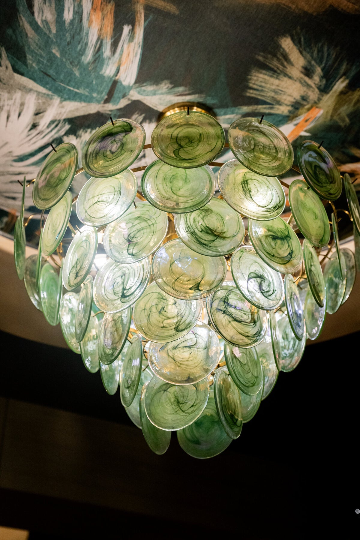 Hand-blown green glass discs of the ColorWave pendant at close range