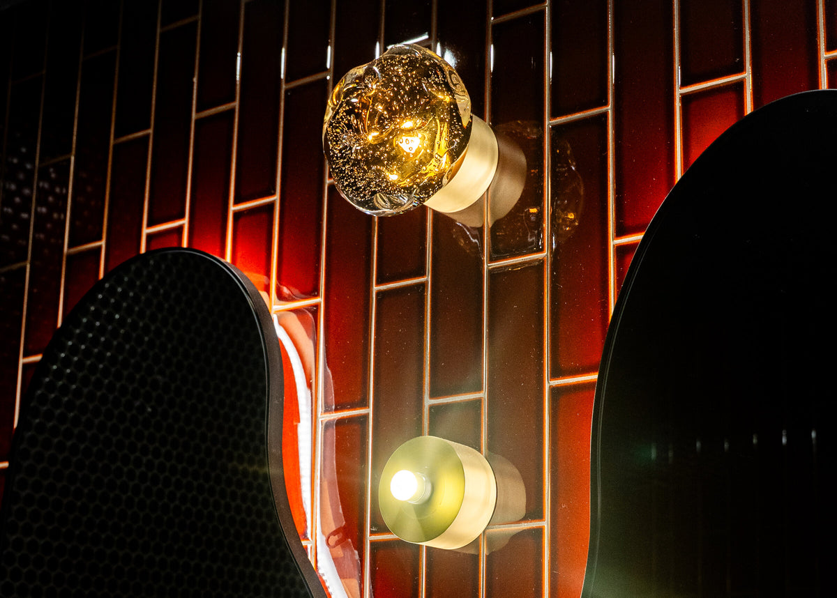 Galaxy wall lamps in crater-textured glass on the ribbed red wall