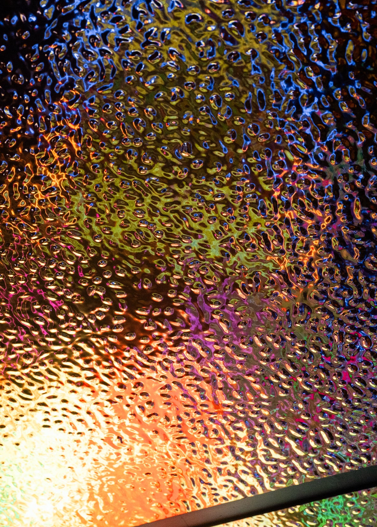 The gold wave panel at close range, carrying colour from the LED banner