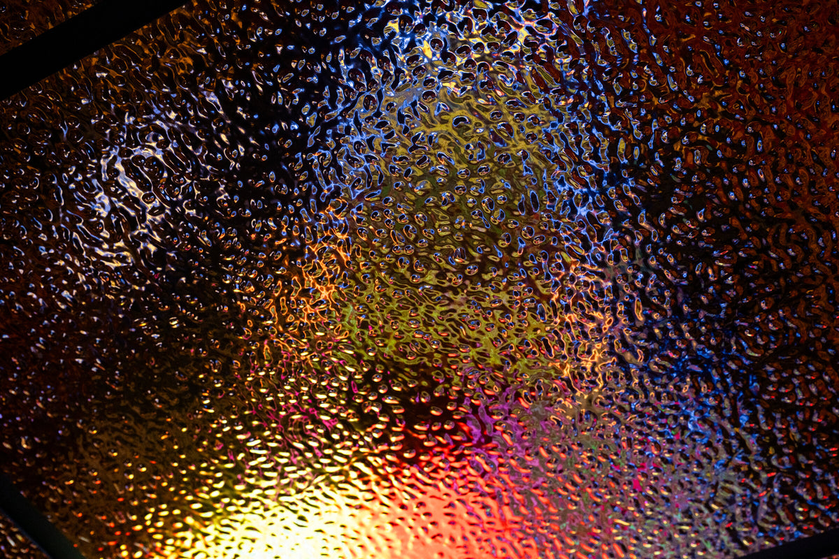 The gold wave panel across the gaming room ceiling, carrying colour from the LED banner