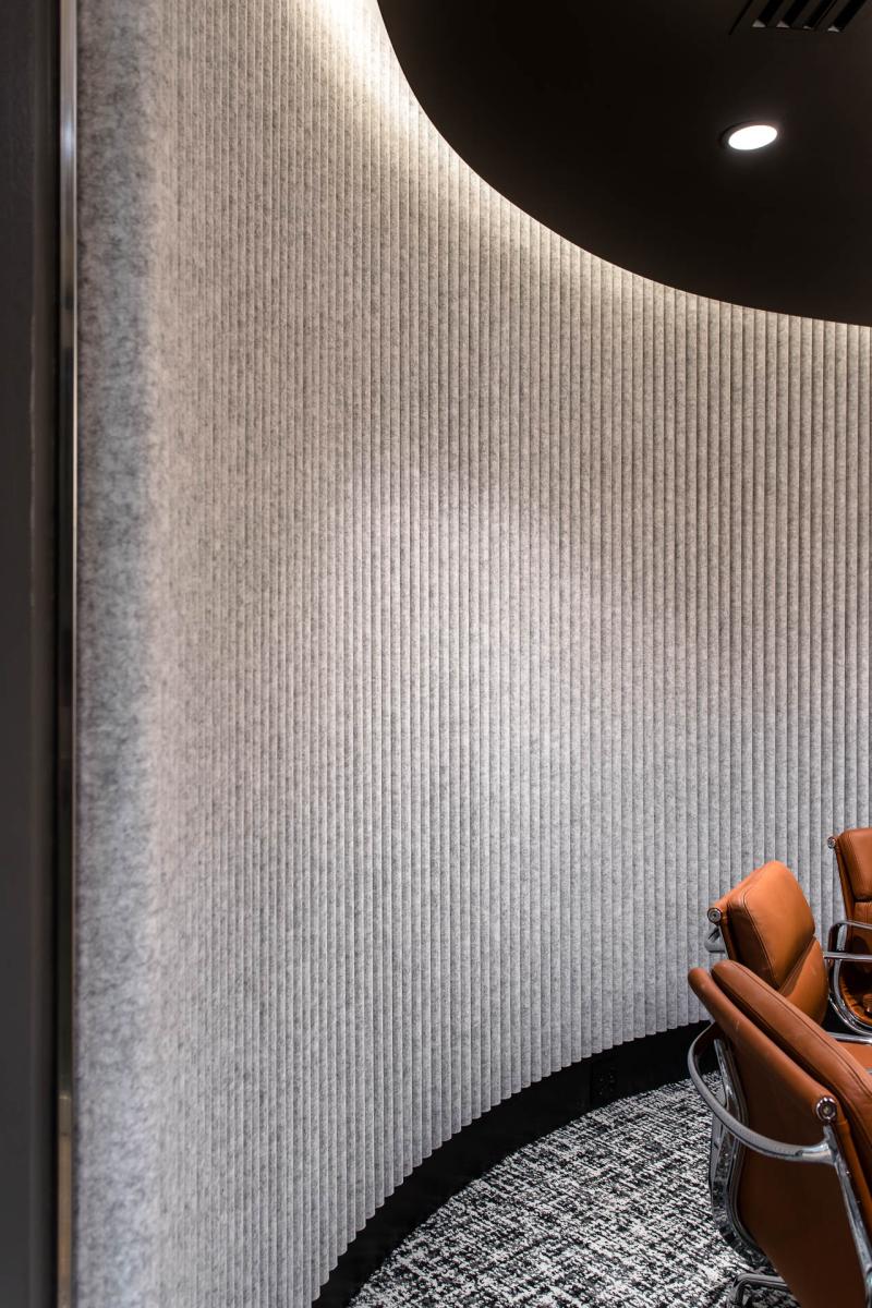 Round line stone architectural wall panels creating a soft textured backdrop in a modern interior space.