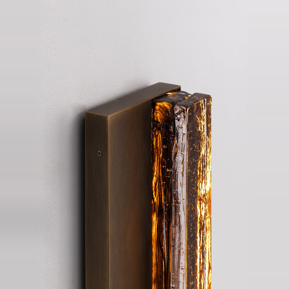 Side detail of the Running Water Duet 1030 brass wall sconce showing its metal backplate and smoked textured glass.