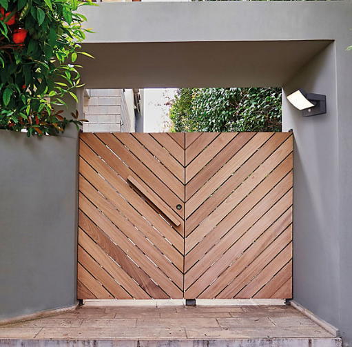 S007 LED sensor wall light installed at a gate entrance, providing bright motion-activated illumination.