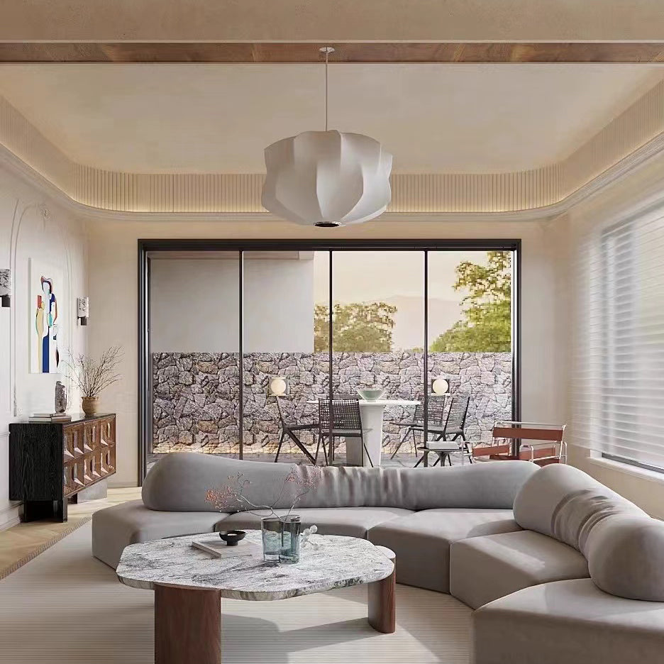 a sculptural pendant light suspended in a living room, emitting soft ambient light that enhances the calm and comfortable atmosphere of the space