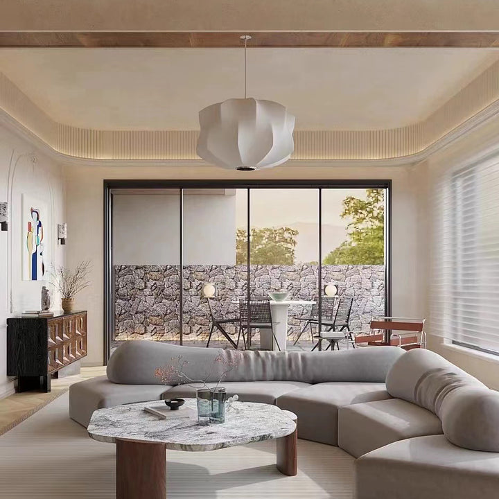 a sculptural pendant light suspended in a living room, emitting soft ambient light that enhances the calm and comfortable atmosphere of the space