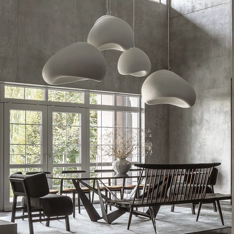 a sculptural pendant light installation arranged at different heights in a living area, producing soft diffused light that enhances the overall ambience