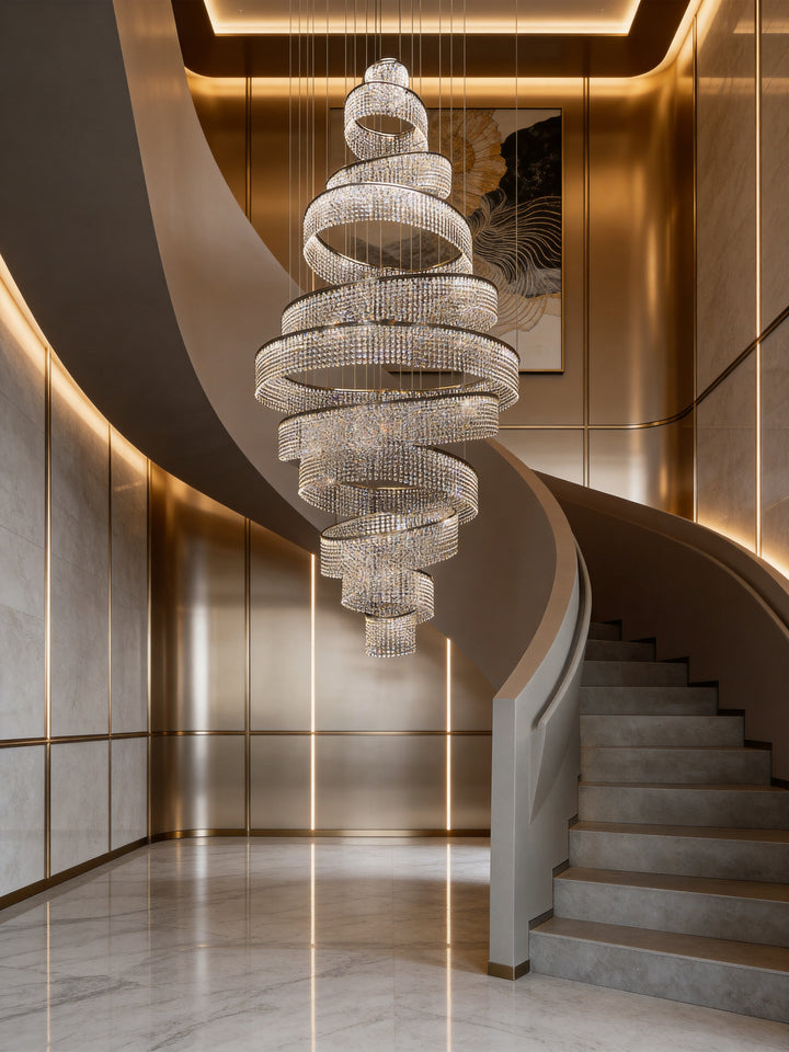 Spiral crystal chandelier in a luxury residential staircase void with warm gold interior and marble flooring, Luminous Eleven Bespoke Lighting by Lucretia