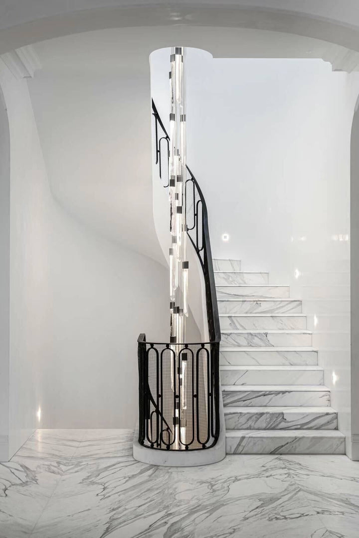 Swedish glass staircase chandelier installed in modern double-height foyer with cascading vertical lighting