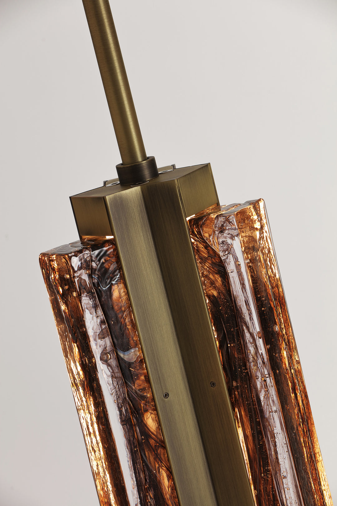Detail of hand-blown textured glass and metal frame, Running Water trio pendant light design