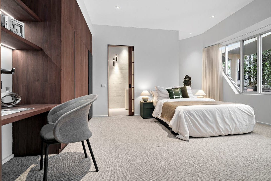 Bedroom with walnut joinery and recessed downlights set into a plain white ceiling