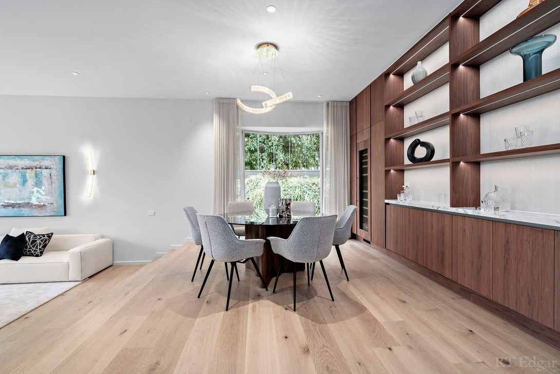 Walnut shelving lit from within each shelf in the dining room