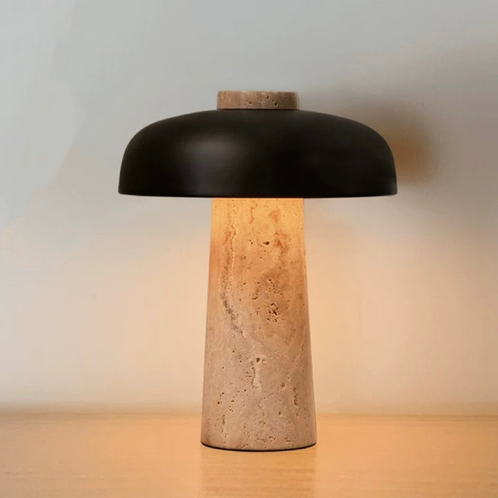 Travertine stone table lamp with black metal shade and warm ambient glow, ideal for bedside tables and modern interiors.