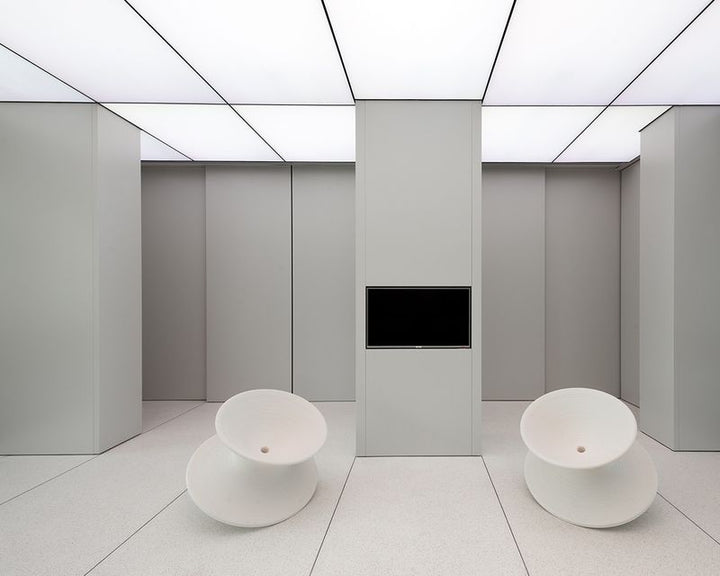 LED stretch ceiling panels illuminating a modern minimalist interior with seamless uniform lighting across walls and ceiling.