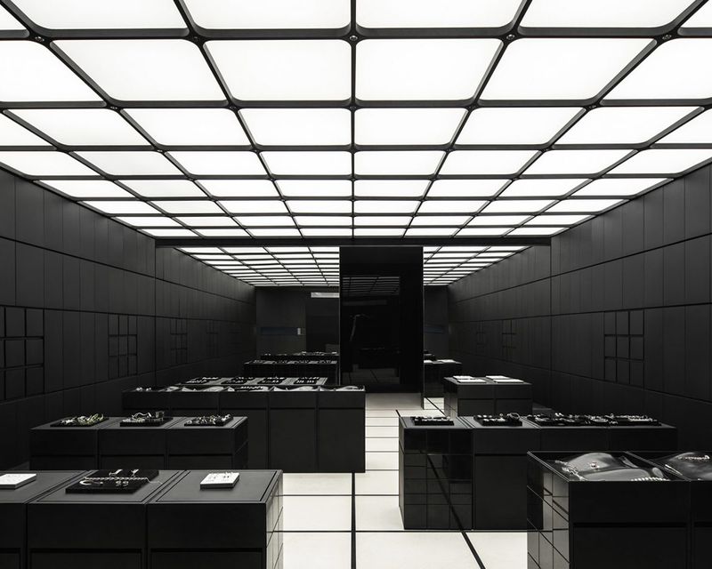 Modular LED stretch ceiling panels illuminating a modern black retail showroom with minimalist display fixtures and architectural lighting design.