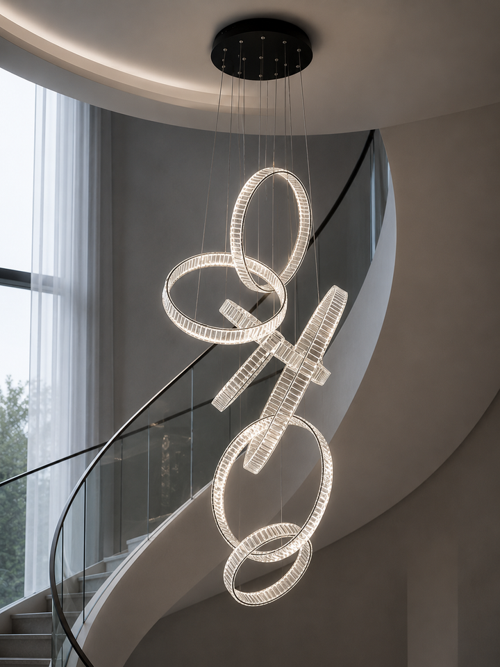 Vertical cascading crystal ring chandelier in a curved residential staircase void with natural daylight and glass balustrade, Pharaoh Vertical Custom Crystal Chandelier by Lucretia
