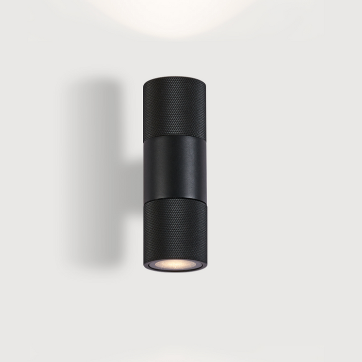 Black architectural up and down wall light with soft diffused illumination.