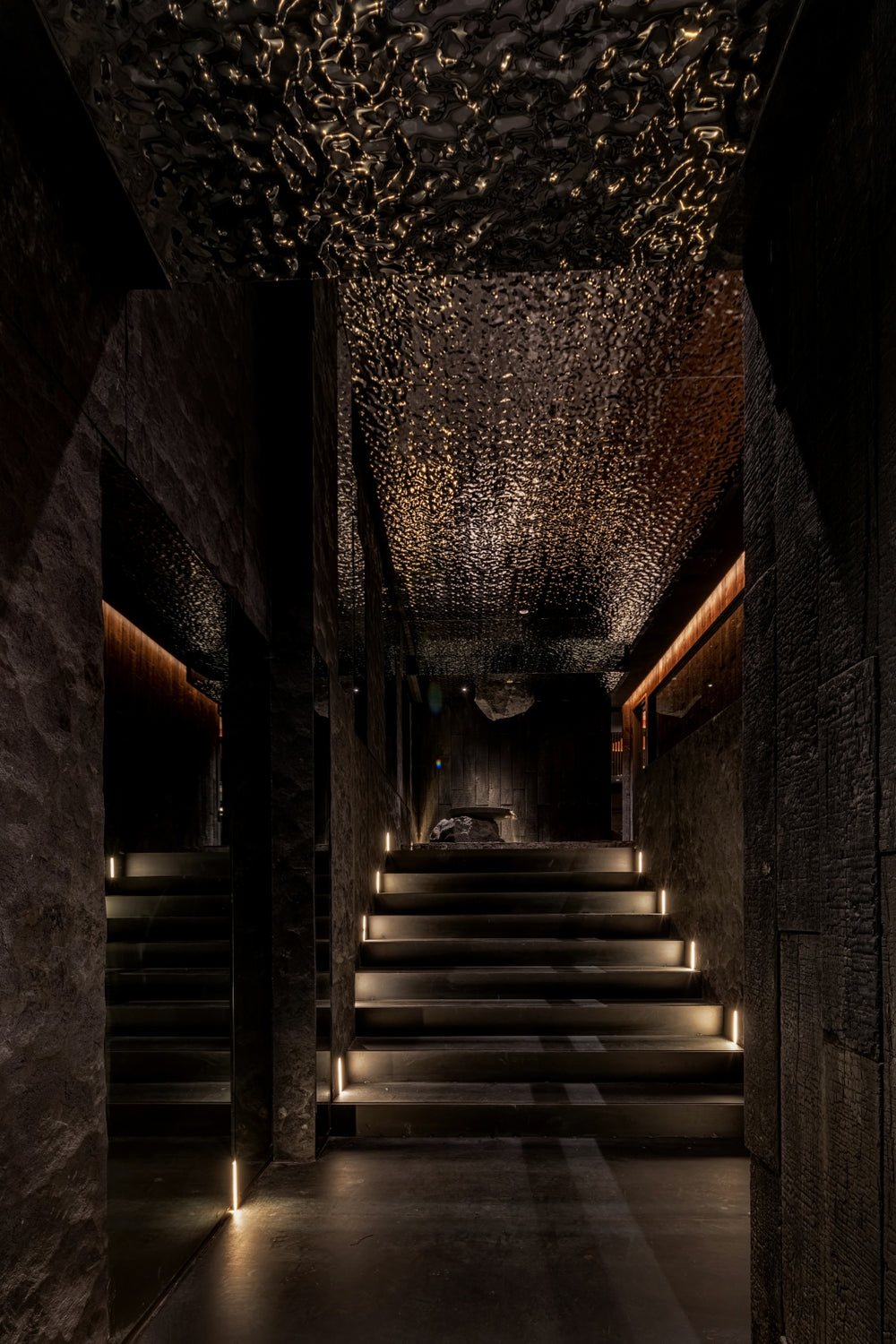 WaveForm 304 stainless steel ceiling panels creating a dramatic wave texture in a dark corridor design