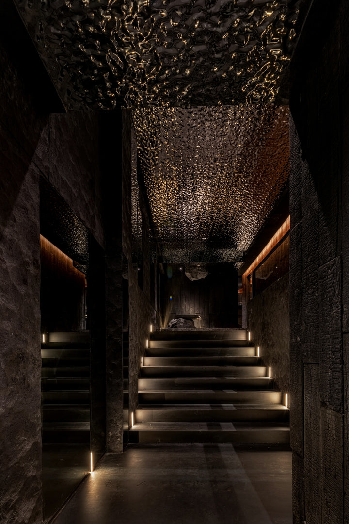 WaveForm 304 stainless steel ceiling panels creating a dramatic wave texture in a dark corridor design