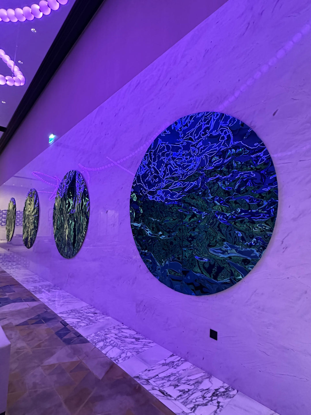 WaveForm 304 stainless steel wall panel with wave pattern enhanced by purple lighting as a feature wall