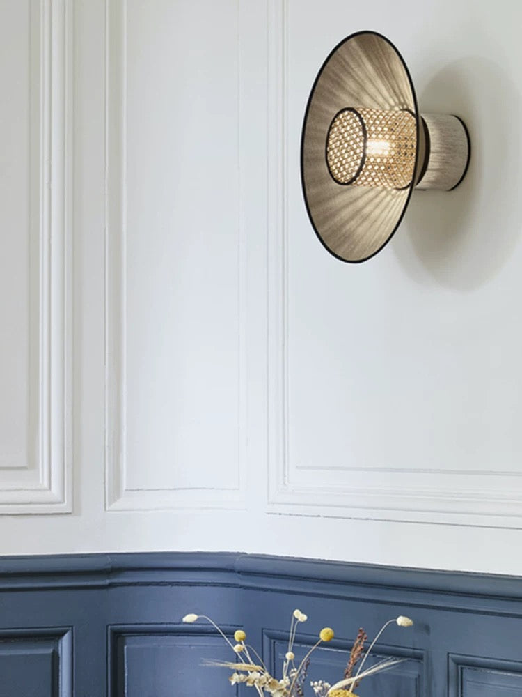 modern woven rattan wall light illuminating a contemporary bedroom with warm ambient lighting
