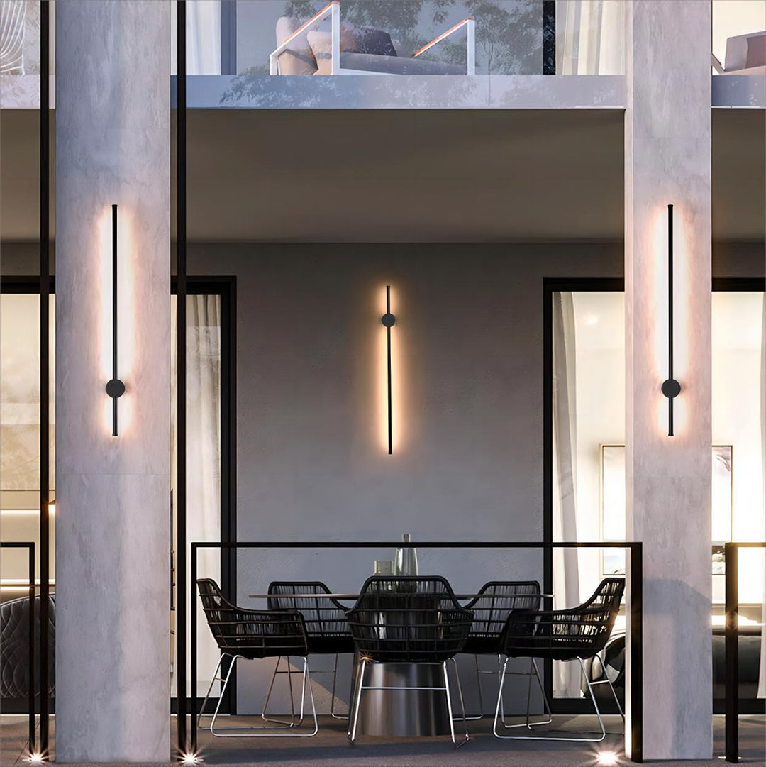 Linear exterior wall light installed on a modern balcony, casting soft vertical illumination on the facade.