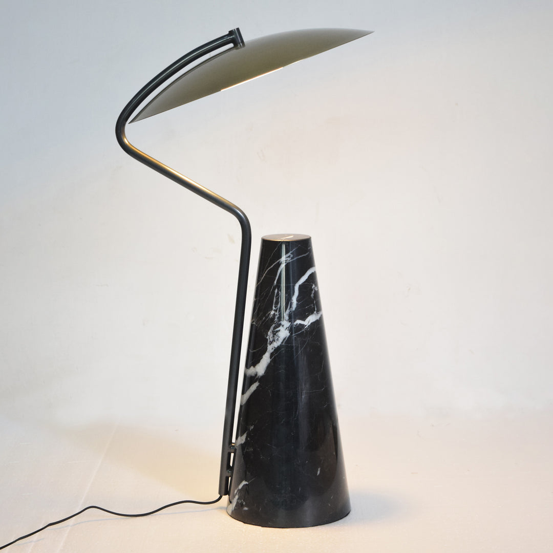 Modern table lamp with black marble base and sculptural angled metal arm, offering warm directed lighting for contemporary Australian homes.