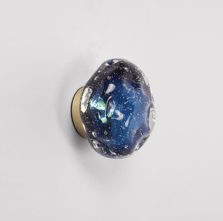 blue galaxy sculptural glass wall lamp providing soft ambient wall lighting with a glowing planet like appearance