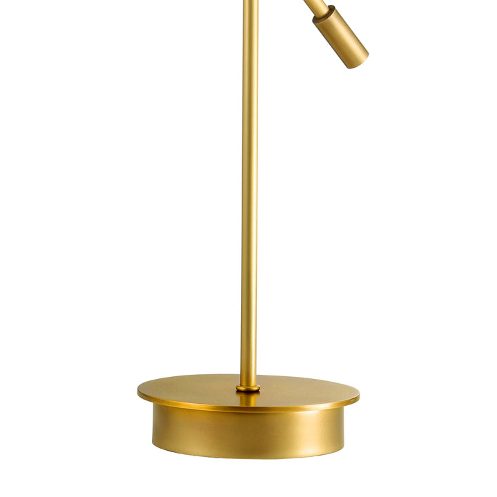 Detail of round brass lamp base providing a stable foundation for modern task lighting in home and office settings.